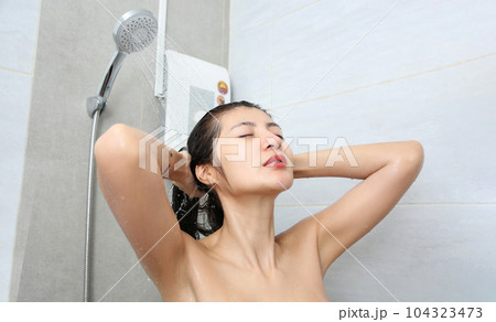 Asian woman being happy with the shower in bathroom. Asian woman being happy with the shower in bathroom. 104323473