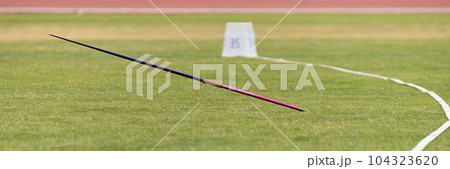 Javelin in field, stuck in the grass, javelin speared into the ground 104323620