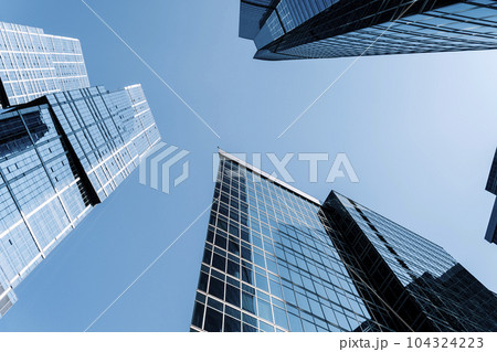 Business skyscrapers and office business center building architecture in perspective on blue sky. Economy, exchange, finance concept. Business skyscrapers and office business center building architecture in perspective on blue sky. Economy, exchange, finance concept. 104324223