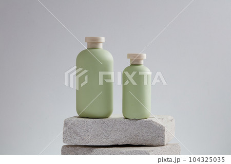 Blank label cosmetic container in pastel color put on stack of stone podiums. Cosmetic package mock up collection for cream, foams, shampoo 104325035