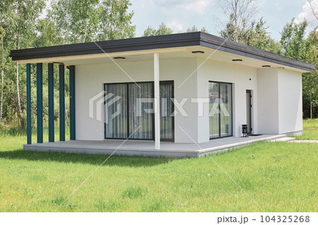 Big white house for rest with big windows and terrace and green lawn palce for recreation on holiday modern bulding for weekend resting. Big white house for rest with big windows and terrace and green lawn palce for recreation on holiday modern bulding for weekend resting. 104325268