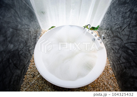 circle bathtub full with bath foam in bathroom circle bathtub full with bath foam in bathroom 104325432