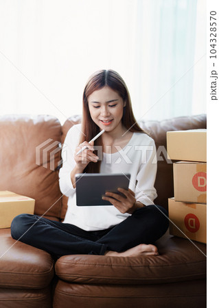 Starting small business entrepreneur of independent young Asian woman online seller is using tablet computer and taking orders to pack products for delivery to customers. SME delivery concept. Starting small business entrepreneur of independent young Asian woman online seller is using tablet computer and taking orders to pack products for delivery to customers. SME delivery concept. 104328570
