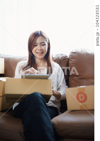Starting small business entrepreneur of independent young Asian woman online seller is using tablet computer and taking orders to pack products for delivery to customers. SME delivery concept. Starting small business entrepreneur of independent young Asian woman online seller is using tablet computer and taking orders to pack products for delivery to customers. SME delivery concept. 104328581