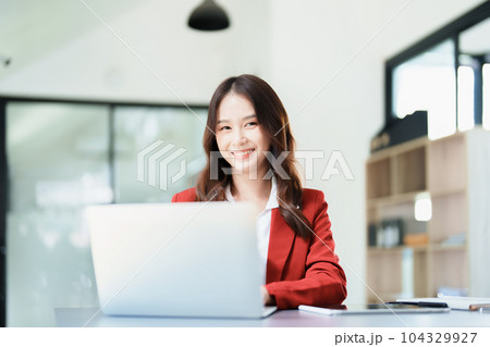 Portrait of a business woman talking on the computer and drinking coffee. 104329927