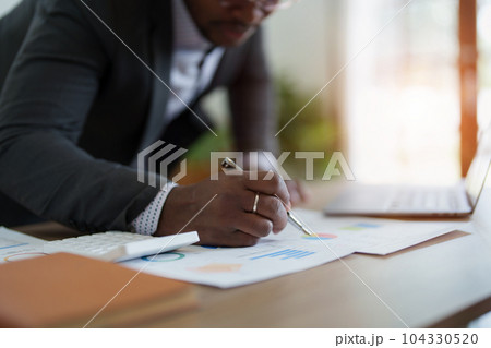 middle aged man American African using computer laptop with planning working on financial document, tax, exchange, accounting and Financial advisor. auditor or audit concepts. 104330520