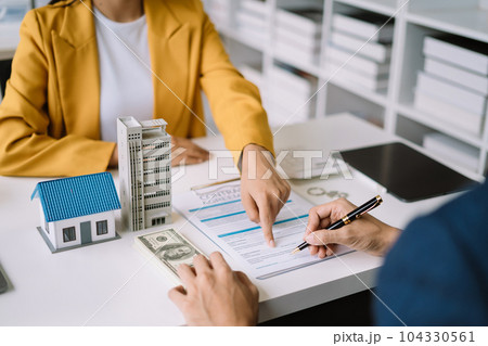 Real estate broker agent presenting and consult to customer to decision making sign insurance form agreement, home model, concerning mortgage loan offer. Real estate broker agent presenting and consult to customer to decision making sign insurance form agreement, home model, concerning mortgage loan offer. 104330561