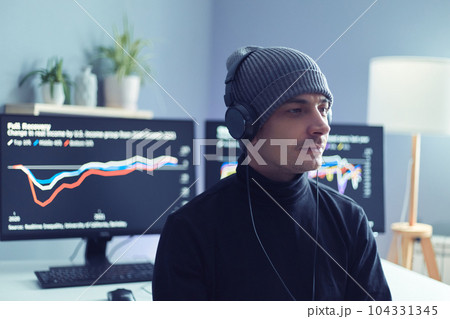 Indoor shot of man trade investor sitting near computer monitors, analyzing candlestick diagram with stock market app, trying to predict actions of money flow, waiting for best moment to buy crypto. 104331345