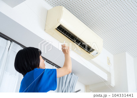エアコンの状態を点検する作業着姿の女性 104331441