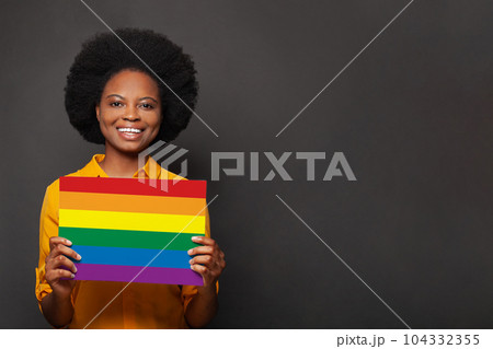 Happy smiling african american woman holding LGBT on black background 104332355
