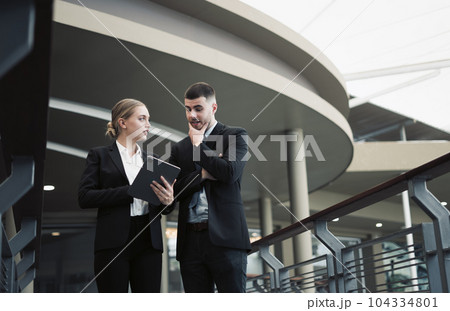Young business couple discussing and using tablet to discuss work outside the office Young business couple discussing and using tablet to discuss work outside the office 104334801
