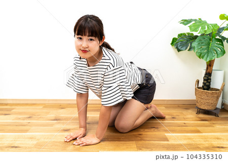 自宅で床に屈む女性 自宅で床に屈む女性 104335310