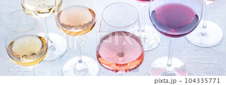 Wine glasses at a tasting. Rose, red, and white wine, drinks on a table 104335771
