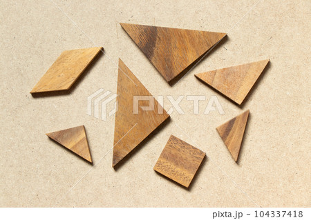 Straggled tangram puzzle  wait to complete the shape on wood background 104337418