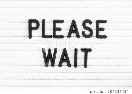 Black color letter in word please wait on white felt board background Black color letter in word please wait on white felt board background 104337454