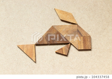 Wooden tangram in swimming fish or carp shape on wood background 104337458