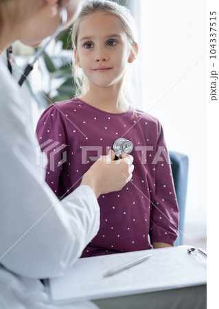 Happy smiling child patient at usual medical inspection. Doctor and kid patient at home. Medicine, healthcare concepts 104337515
