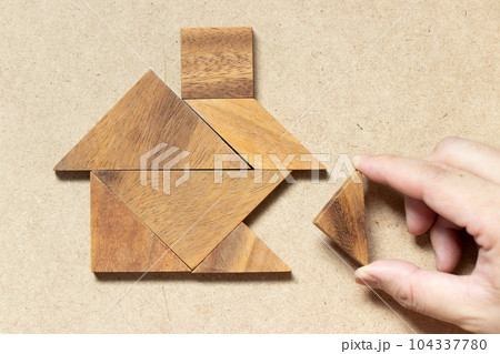 Wooden tangram puzzle wait to fulfill home shape for build dream home, happy life, house or mortgage investment concept 104337780
