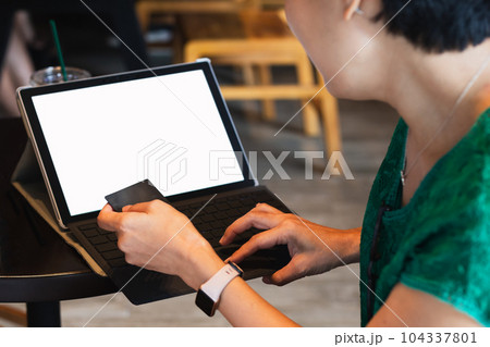 Businesswoman pay bills online on credit card using laptop computer at cafe. 104337801