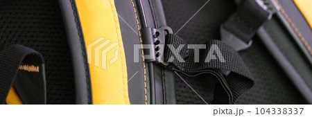 Shoulder straps in yellow and black backpack for comfortable carrying on back closeup 104338337