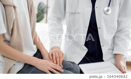 Doctor and child patient. The physician is holding clipboard and reassuring a boy. The concept of ideal health in medicine 104340682