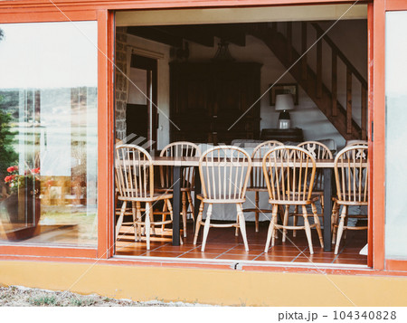 Open room with wooden furniture, large sliding windows Open room with wooden furniture, large sliding windows 104340828