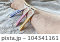 ピンクと黄色と青色の使い捨てカミソリとムダ毛の生えた女性の脛 104341161