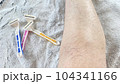 ピンクと黄色と青色の使い捨てカミソリとムダ毛の生えた女性の脛 104341166