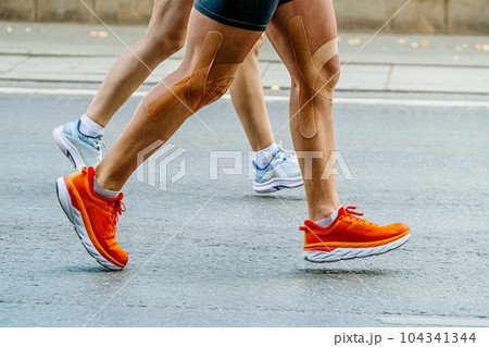 close-up legs couple runners man and woman running marathon race together close-up legs couple runners man and woman running marathon race together 104341344