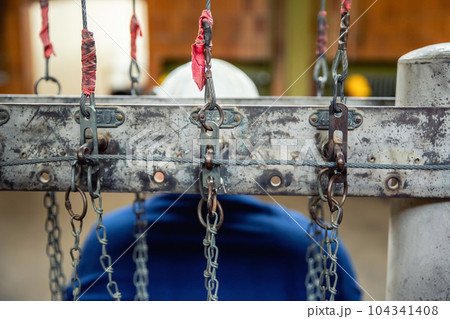 Close-up detail view old rusty chain lock row at miner's clothing room hall against jobeless miner abandoned ore mine Rammelsberg Goslar Harz Germany. Unemployement and industry recession background Close-up detail view old rusty chain lock row at miner's clothing room hall against jobeless miner abandoned ore mine Rammelsberg Goslar Harz Germany. Unemployement and industry recession background 104341408