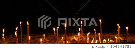 Burning candles in the church on a dark background. The idea of prayer and religion 104341785