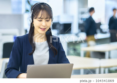 オフィスで働く笑顔の若い女性オペレーター オフィスで働く笑顔の若い女性オペレーター 104341869