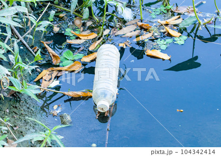Waste from plastic bottle floating on water surface in river is a problem and water pollution in evening. Eastern of Thailand drain water into sea. In nature day light. Waste from plastic bottle floating on water surface in river is a problem and water pollution in evening. Eastern of Thailand drain water into sea. In nature day light. 104342414