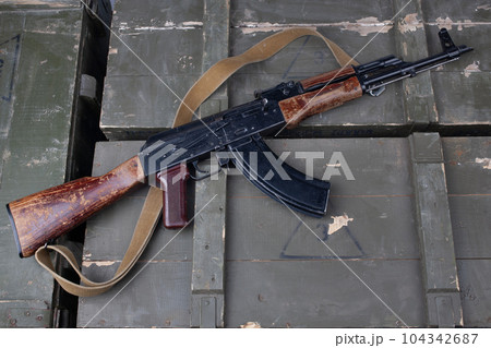 Kalashnikov AK47 gun on army green crates Kalashnikov AK47 gun on army green crates 104342687
