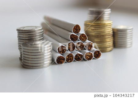 Copper and silver coins in columns show the growth of the tobacco market  104343217