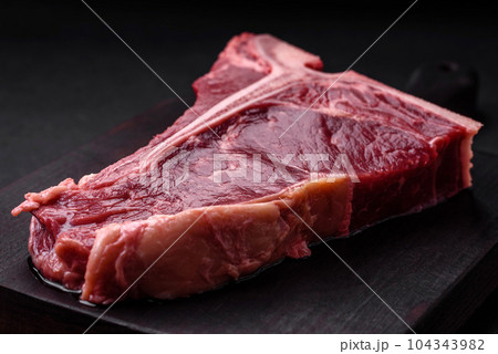 Raw juicy beef t-bone steak with salt, spices and herbs Raw juicy beef t-bone steak with salt, spices and herbs 104343982