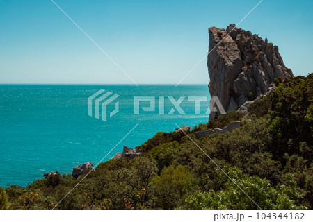 A high sheer cliff, beautiful blue sea and sky. A high sheer cliff, beautiful blue sea and sky. 104344182