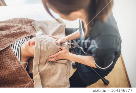 顔周りをマッサージされる若い女性 顔周りをマッサージされる若い女性 104346577