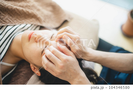 顔周りをマッサージされる若い女性 104346580