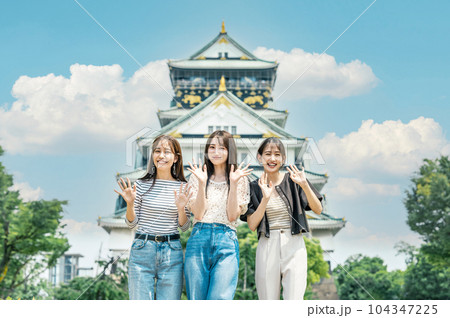 友達と旅行で大阪城を訪れる女性 104347225