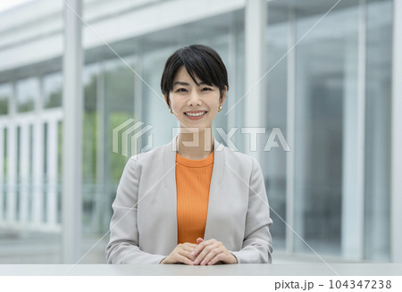 カメラ目線で笑顔の30代のビジネスウーマン 104347238