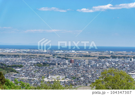 郊外の街並み、田植え前の田園風景 郊外の街並み、田植え前の田園風景 104347307