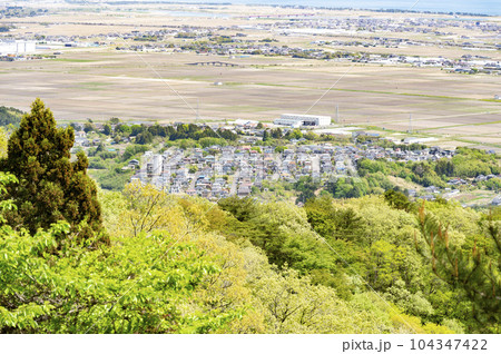 郊外の街並み、田植え前の田園風景 郊外の街並み、田植え前の田園風景 104347422