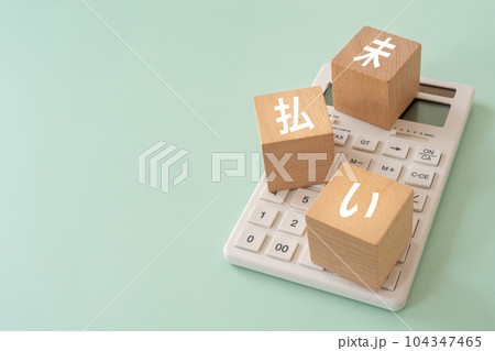 未払いのイメージ｜木のブロックと電卓 104347465