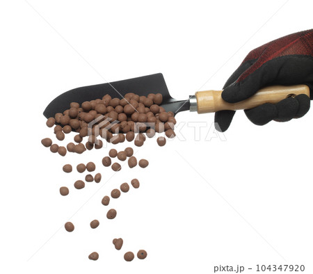 Clay Drainage big size ball pour fall down, explosion in shovel hand. Clay Drainage ball splash in shape form line explosion. White background isolated high speed shutter freeze motion 104347920