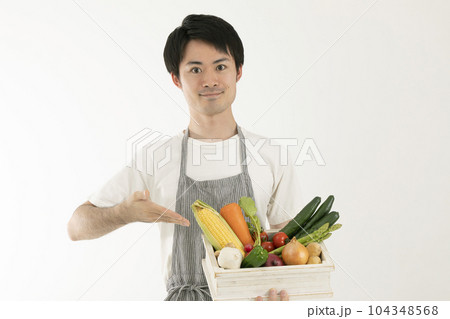 箱詰めの野菜をもつ男性　man with a box of vegetables 104348568