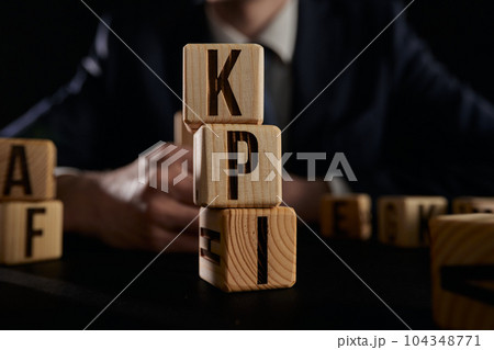 Businessman made word kpi with wood building blocks. 104348771