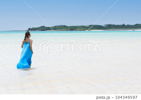 どこまでも繋がる遠浅の海を歩く休暇を楽しむ若い女性 104349597