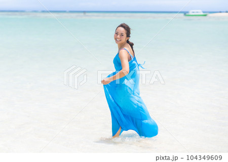 どこまでも繋がる遠浅の海を歩く休暇を楽しむ若い女性 どこまでも繋がる遠浅の海を歩く休暇を楽しむ若い女性 104349609