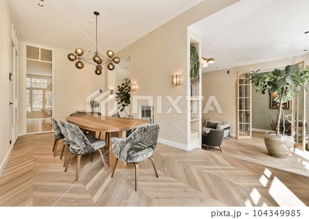 a dining room with wood flooring and white walls, an open door to the living room is in the background a dining room with wood flooring and white walls, an open door to the living room is in the background 104349985